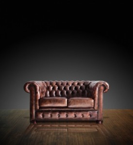 Classic Brown leather sofa on wood in darkroom background