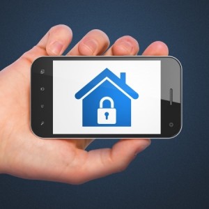 Safety concept hand holding smartphone with Home on display Generic mobile smart phone in hand on Dark Blue background