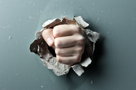 a wall is broken through by a fist