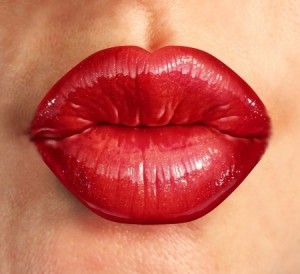 Human kiss lips with glamorous glossy red lipstick