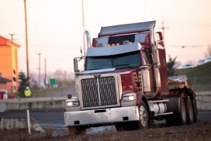 Big red semi truck turn on the highway ramp