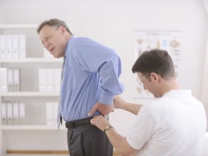 Physiotherapist examining senior man at office