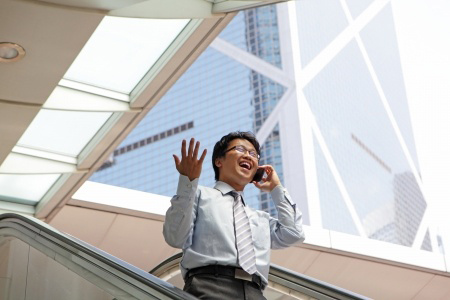Young business man talking on cell phone at modern office, asian male