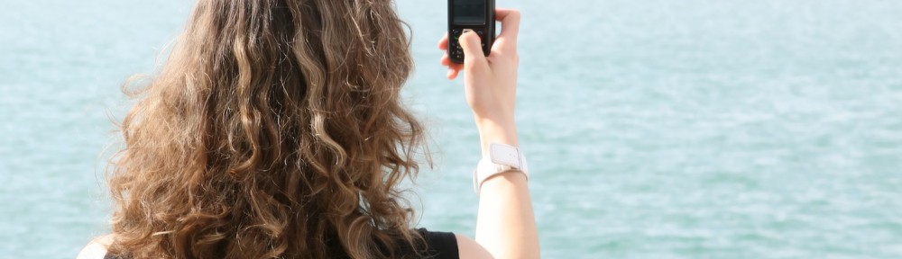 Tourist on holiday using mobile cell phone