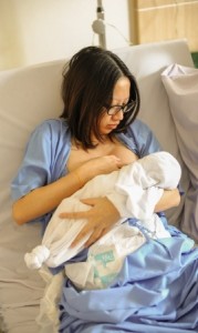 Beautiful new mother happy holding her infant baby feeding her milk after giving birth in hospital