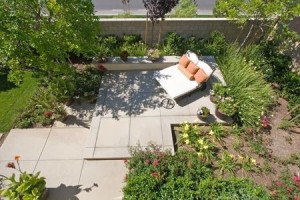 Backyard oasis and suburban retreat with flowers, lounge chair, and patio