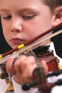 Cute young boy playing the violin
