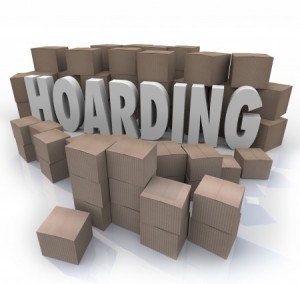 he word Hoarding surrounded by cardboard boxes piled up in an out of control messy collection of items, junk and trash