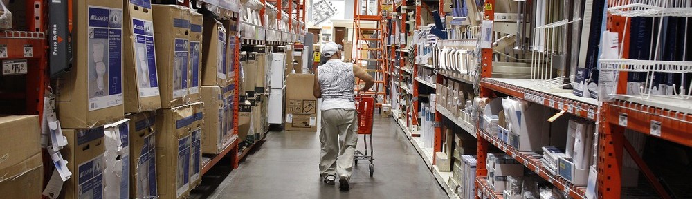 Image: A man pushes his shopping cart down an aisle at a Home Depot store in New York