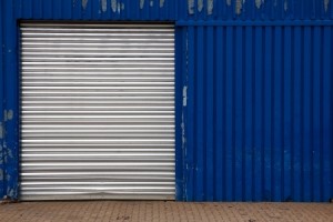 Closed door on a worn blue industrial metal shed at a shipyard in Hamburg, Germany