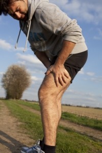 Man touching his thigh during running because of pain
