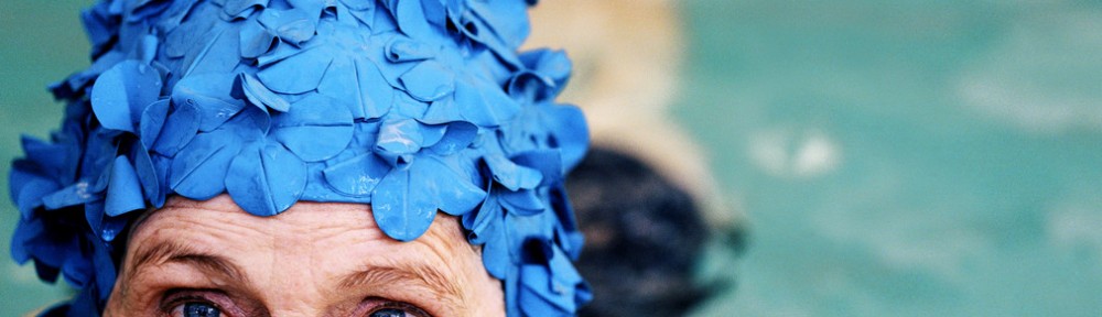 Elderly Woman Smiling Wearing a Swimming Cap in a Swimming Pool