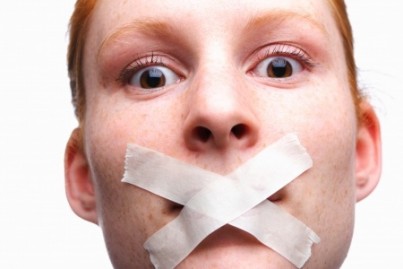 Face of a young woman with tape on her mouth