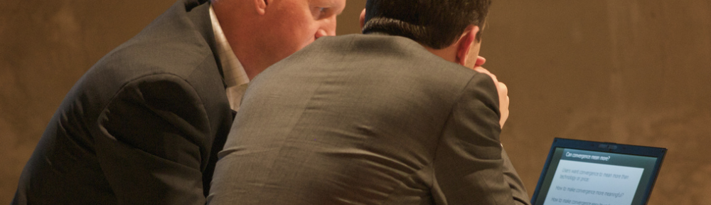 TwoBusinessmenHuddlingConference