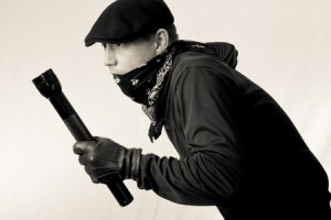 sneeky burglar in black and white with a flashgligh