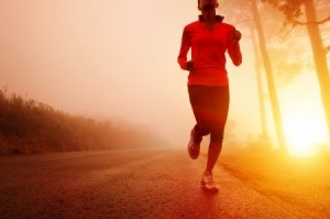 Athlete running on the road in morning sunrise training for marathon and fitness Healthy active lifestyle latino woman exercising outdoors