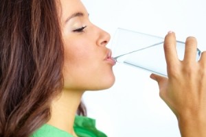 Close-up of pretty girl drinking water from glass