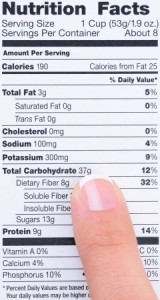 Closeup of a woman's finger pointing at a food product nutrition label