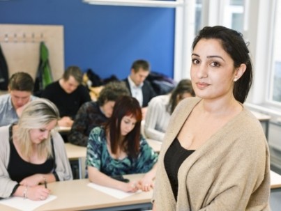 Schoolteacher in front of pupils in the classroom