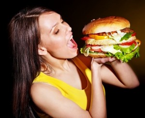 Slim woman bite big hamburger