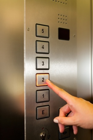Woman in elevator or lift is pressing the button