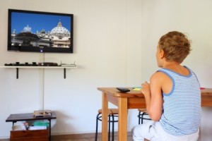little boy in striped shirt sitting at table and watching TV, photo by Pavel Losevsky on TV