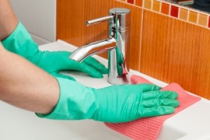 A man cleaning a sink with a rag