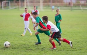 kids running with ball on football match