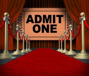 Entertainment on the red carpet theatrical cinema concept with an admit one movie ticket behind red velvet curtains and drapes as a symbol of an important creative stage performance event