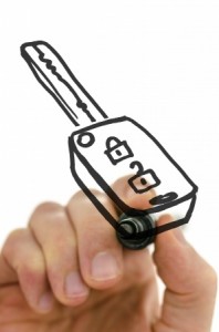 Detail of male hand drawing car key on a virtual board with black marker.
