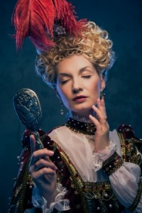 Haughty queen in royal dress with mirror