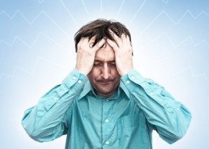 Young businessman looking anxious and worried, having a headache