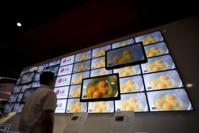 A wall of TV towers over an onlooker at the 2009 Consumer Electronic Show held in Las Vegas