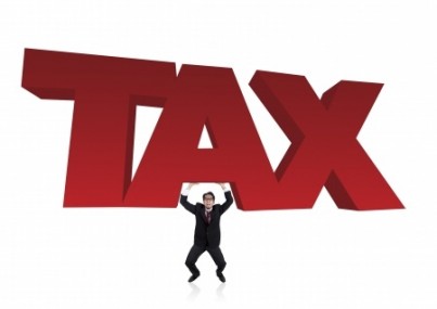 Worried bussinessman lifts a tax sign