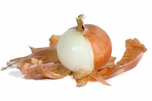 Sweet onion with brown skin half peeled and isolated on white with path.