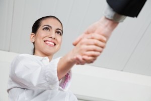 Handshake with a smiling businesswoman in the office