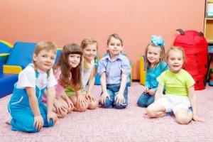 Six friendly kids sitting in the kindergarten