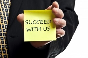 Succeed with us post it in business man hand