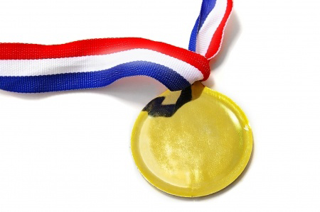 a blank gold medal with ribbon, on white