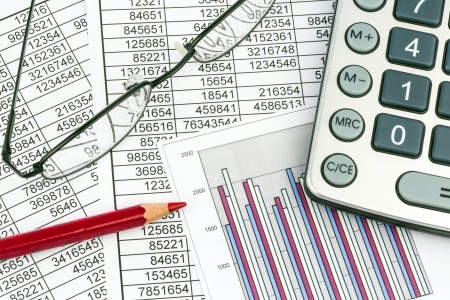 a calculator is on a balance sheet numbers are statistics photo icon for sales, profit and cost
