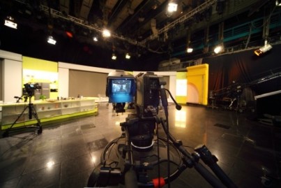 professional black video camera in television studio, light scen