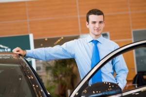 dealer stands near a new car, car dealerships