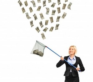 A businesswoman with a net trying to catch money isolated on white background