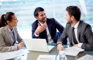 Portrait of three co-workers discussing business plan in office