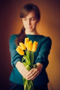 Young woman girl holding bouquet of yellow flowers tulips