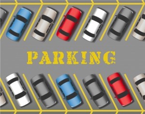 Many cars parked in store or business parking lot filling all the spaces