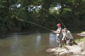 Fly fishing a gillie instructing a pupil River Lyd Devon UK