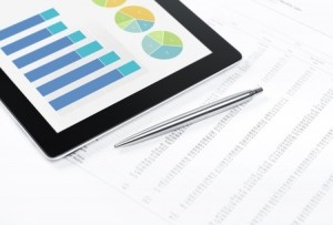Modern workplace with digital tablet showing charts and diagram on screen