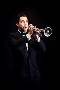 Portrait of a musician playing the trumpet. Black background