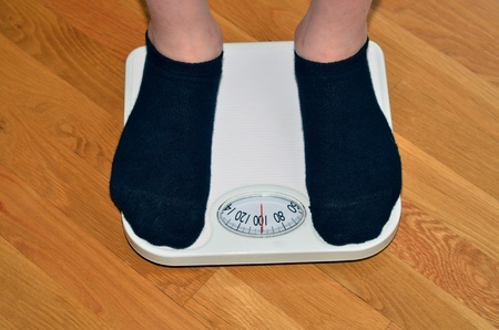 Young man standing on a scale getting his weight